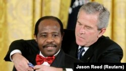 George Bush amerikai elnök (jobbra) az Elnöki Szabadság Érdemrenddel tünteti ki Paul Rusesabaginát,  Washington, 2005. november 9.