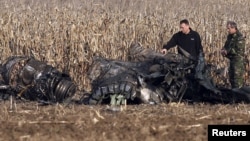 Oficiali ai armatei române inspectează epava unui MiG-21 LanceR, care s-a prăbușit în timp ce ateriza lângă satul Călugăreni, în noiembrie 2010