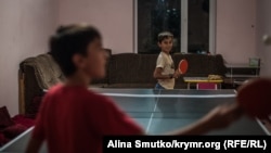 Саїд і Мамут (9 років) грають в настільний теніс будинку в Бахчисараї