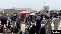 Oameni adunați în fața aeroportului din Kabul în speranța de a putea părăsi Afganistanul, după venirea la putere a milițiilor Taliban, 17 august 2021.