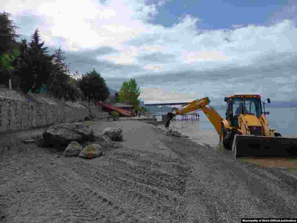 Një ekskavator, që raportohet se është angazhuar nga Komuna e Ohrit, përdoret për të pastruar bregun maqedonas të liqenit, në maj. &nbsp; Aktivistët vendës, si ata nga &quot;OhridSOS&quot;, thonë se rrënimet e fundit të kryera përreth liqenit po bëhen sa për sy e faqe, për të qetësuar monitoruesit e UNESCO-s. &nbsp;