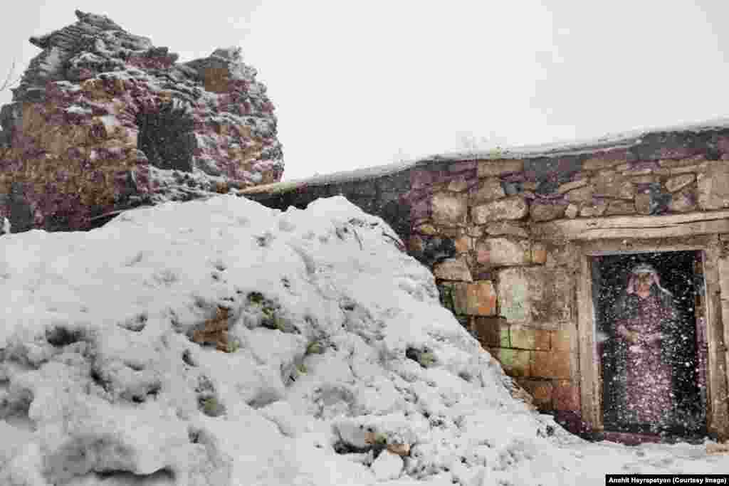 Эта женщина стоит рядом с тандыром (печью), построенным из развалин церкви.