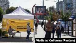 Учасники кампанії владної партії «Дія і солідарність» (PAS) роздають листівки перед майбутніми парламентськими виборами в Молдові, Кишинів, 21 вересня