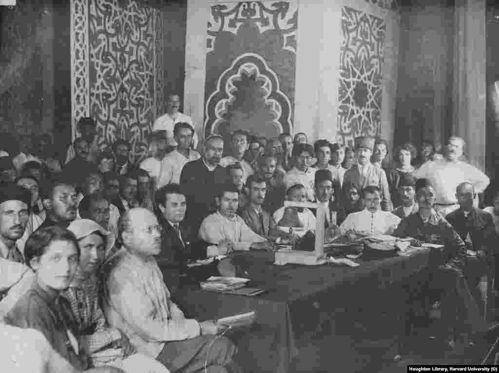 Рид, облечен с бяла риза (в центъра вляво), по време на комунистическа политическа среща в Баку. Разочарованието на Рид от болшевиките на Ленин се засилва през 1920 г., когато е изпратен в Баку, в съветски Азербайджан, за да присъства на многонационална среща на Комунистическия интернационал. По време на дългото пътуване с влак обратно до Москва Рид наблюдава как служители на Коминтерна се глезят &bdquo;с поръчка от екзотични храни, безкрайни доставки на алкохол и млади проститутки, някои от които може би са били на 14 години&ldquo;.