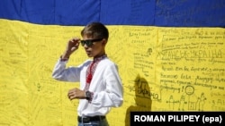 Хлопчик на тлі українського прапора із побажаннями та вдячністю оборонцям України. День Незалежності України. Київ, 24 серпня 2015 року