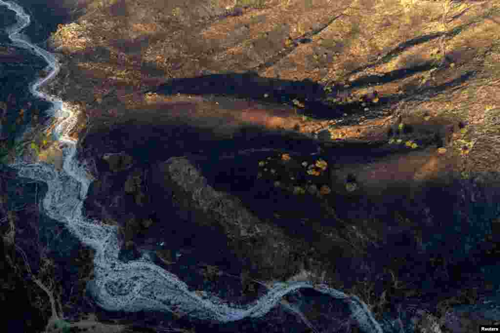 Снимок с беспилотника, на котором запечатлены последствия лесного пожара недалеко от Дельвины, Албания, 28 июля 2025 года. REUTERS/Florion Goga