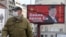 Serbia - A man wearing a protective mask passes by a billboard depicting Chinese President Xi Jinping as the spread of the coronavirus disease (COVID-19) continues in Belgrade, Serbia, April 1, 2020. 