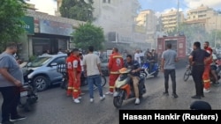 Vatrogasci u blizini prodavnice mobilnih telefona u Sidonu, na zapadu Libana, iz koje se diže dim, 18. septembar 2024. 