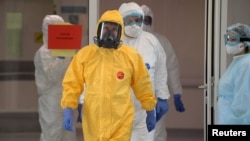 Президент Росії Володимир Путін, одягнений у захисний одяг жовто-синього кольору, в лікарні для пацієнтів, інфікованих коронавірусом. 24 березня 2020 року