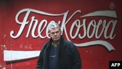 Albanac prolazi pored grafita na zidu zgrade u Kosovskoj Mitrovici