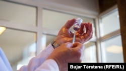 Një punëtor shëndetësor në Kosovë duke u përgatitur që të administrojë një dozë të vaksinës kundër koronavirusit. 