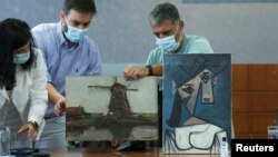 Специалисти показват в Атина "Мелница" на Пийт Мондриан (вляво) и "Глава на жена" на Пабло Пикасо. Двете картини бяха показани за пръв път на 29 юни 2021, след като през 2012 г. бяха откраднати от Националната галерия на Гърция.