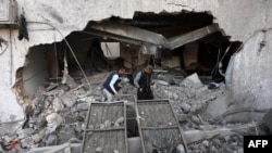 Израил армиясынын чабуулунан улам талкаланган үйдүн урандыларынын алдынан жакындарын издегендер. 13-апрель, 2025-жыл.