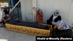 Ооруканадагы өрттөн көз жумган маркумдун cөөгү жана жакындары. 13-июль, 2021. Ирак.