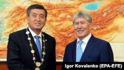New Kyrgyz President Sooronbai Jeenbekov (C) shakes hands with former president Almazbek Atambaev during an inauguration ceremony of the new president at the Ala-Archa state residence in Bishkek on November 24.