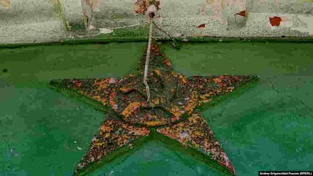 Un simbol sovietic în descompunere într-un vechi cămin dintr-o fabrică din districtul&nbsp;Admiralteiskaia (Bișbalta în limba tătară) din Kazan, Republica Rusă Tatarstan, pe 1 august.&nbsp;(Andrei Grigorev, RFE/RL) Districtul va marca cea de-a 305-a aniversare în 2023. A fost fondat de domnitorul rus Petru cel Mare în 1718. A fost inițial un centru pentru construcțiile navale rusești și în perioada sovietică era cunoscut pentru producția de obiecte din piele și decechipamente medicale. Autoritățile au promis că vor reconstrui cartierul istoric de mai multe&nbsp;ori, dar nu s-au ținut de oprimisiune.