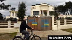 O fotografie din februarie 2022, la trei zile după invazia rusă din Ucraina, arată că localnicii știau foarte bine a cui este clădirea. Pe gard se putea citi o injurie la adresa președintelui Putin.