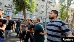 Njerëzit ndihmojnë një person të plagosur pas një shpërthimi në qytetin e Gazës, 5 gusht 2022.