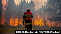 Un pompier din Franța privește la o pădure în flăcări. Franța este una dintre cele mai afectate țări de incendiile de vegetație din ultimele zile. 