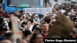 Demonstrant nosi transparent na kojem piše "Mi smo pozorište" na protestu u Tirani u ponedeljak, 18. maja
