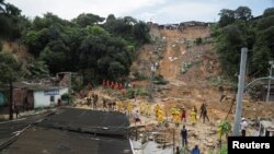 Zaposleni u gradskoj vijećnici, vatrogasci, volonteri i vojni oficiri rade na mjestu gdje su se kuće srušile zbog klizišta u Recifeu, Brazil, 30. maja 2022.
