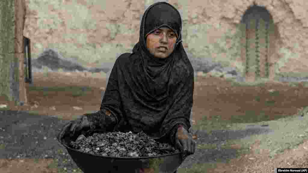 O fetiță de 9 din Afganistan lucrând la o fabrică de cărămidă de la periferia capitalei Kabul, 20 octombrie 2022. Agențiile umanitare spun că numărul copiilor folosiți ca forță de muncă în Afganistan a crescut după ce economia țării s-a prăbușit în urma preluării puterii de cître Talibani acum mai mult de un an.&nbsp;(AP Photo/Ebrahim Noroozi)
