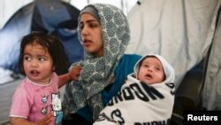 Сирійська біженка з дітьми в таборі для біженців на греко-македонському кордоні. Греція, травень 2016 року
