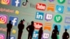 Small toy people figures are seen in front of displayed social media logos in this illustration taken, May 25, 2021.