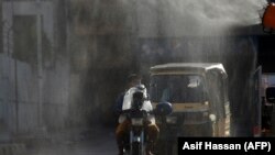 Workers spray disinfectant along a street during a government-imposed nationwide lockdown as a preventive measure against the spread of the COVID-19 coronavirus in Karachi on May 4.
