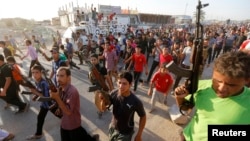 In Baghdad, members of a Shi'a militia parade through the streets.