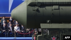 Vlagyimir Putyin és Dmitrij Medvegyev egy interkontinentális ballisztikus rakéta hátterében a győzelem napi parádén 2013. május 9-én Moszkvában