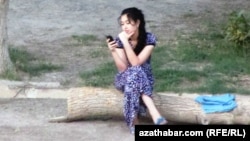 Mobil telefonly bir gyz. Arhiwden alnan illýustrasiýa suraty.