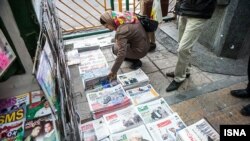 Iran -- People look at local newspapers on sale in Tehran, 25Nov2013