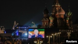 Imaginea lui Vladimir Putin pe un ecran în timpul transmisiunii unui concert care marchează anexarea declarată a teritoriilor controlate de Rusia din patru regiuni ucrainene Donețk, Luhansk, Herson și Zaporojie