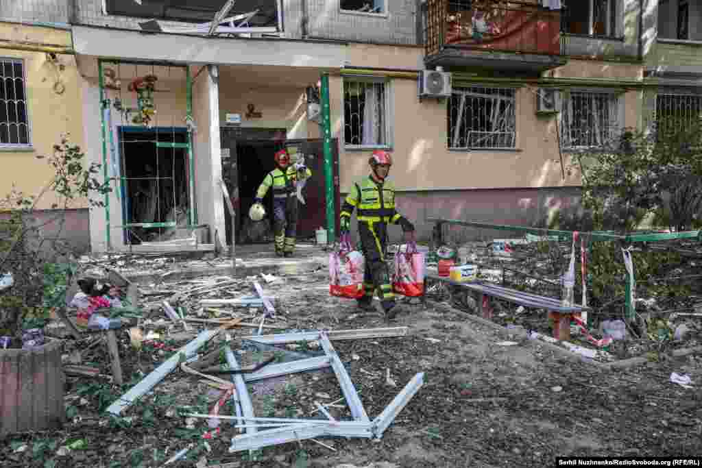 Рятувальники допомагають місцевим мешканцям винести уцілілі речі з будинку, який був пошкоджений внаслідок атаки РФ. Київ, 1 серпня 2025 року