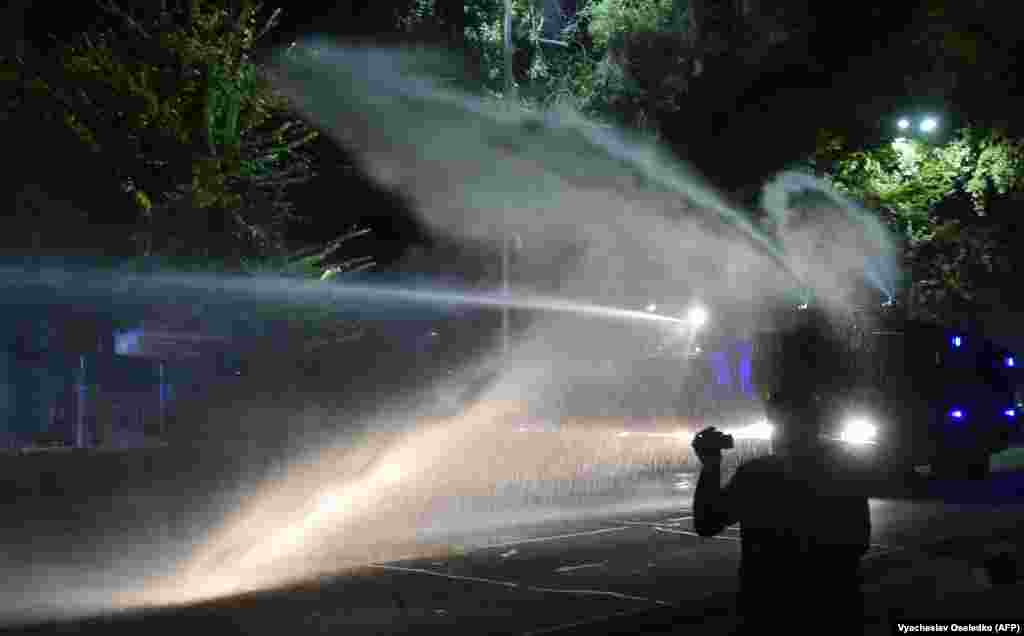 A rendőrség vízágyút vet be a demonstrálók ellen.