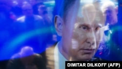 Chipuri ale spectatorilor reflectate în ecrane în timpul adresării televizate a lui Vladimir Putin