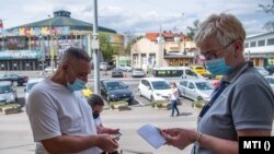 Egy látogató védettségi igazolványát ellenőrzik a fővárosi Széchenyi fürdő bejáratánál, 2021. május 1-jén