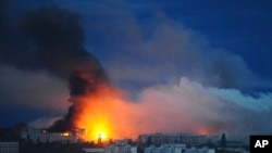 Foc și fum se ridică dintr-o zonă rezidențială din Harkov, Ucraina, atacată de o rachetă rusească. Imagine de sâmbătă, 7 iunie 2025.