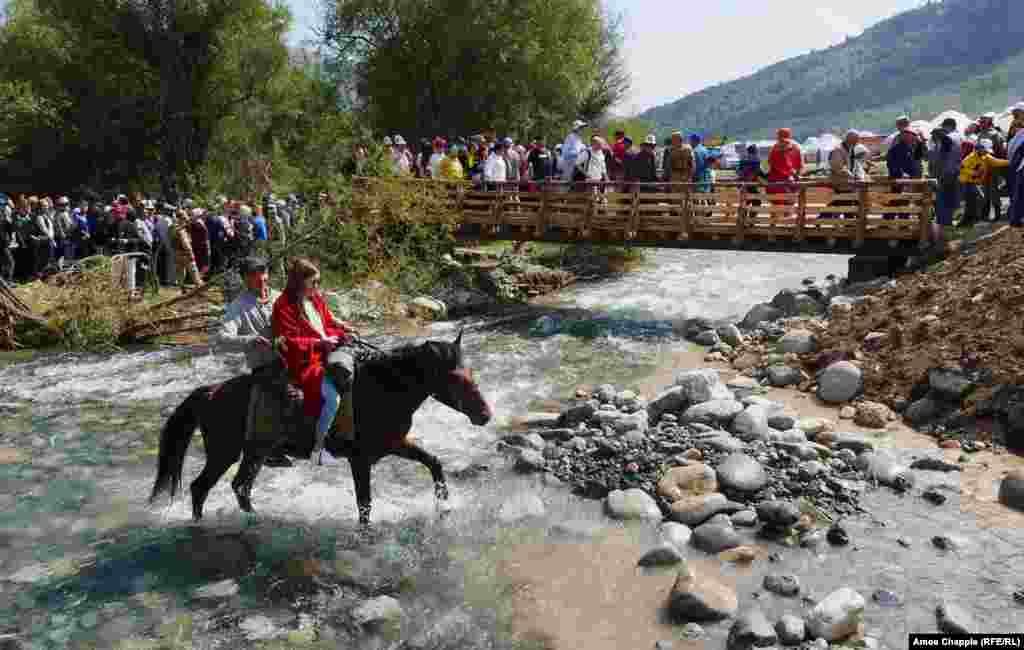 Young locals take the low road as their horse clatters through a mountain stream on the way to the opening ceremony at Kyrchyn Gorge.