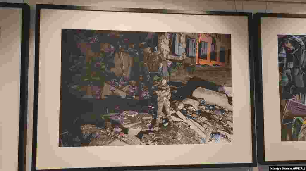 Українська військова на фоні зруйнованого будинку