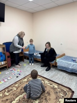 Angelina Jolie le zâmbește unor copii într-un adăpost din Herson.