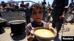 Палестинците чекаат да добијат храна од добротворна кујна во градот Газа