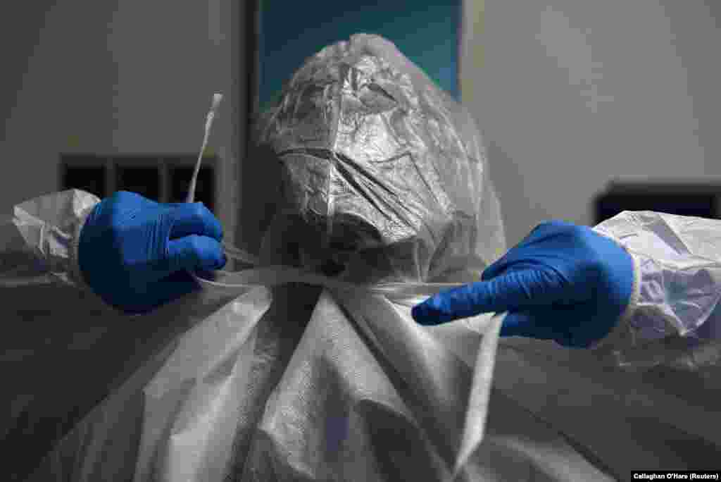 Медработник надевает защитный костюм в отделении интенсивной терапии в United Memorial Medical Center. Хьюстон, штат Техас