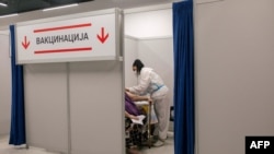 Egy szerb egészségügyi dolgozó bead egy adag koronavírus elleni vakcinát egy oltási központban egy belgrádi bevásárlóközpontban 2021. május 6-án.