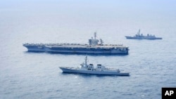 Distrugătorul Seoae Ryu Sung-ryong al marinei sud-coreene, în partea de jos, portavionul Theodore Roosevelt al Marinei SUA, în centru, și distrugătorul Ariake al Forței Maritime de Autoapărare a Japoniei, sus, în timpul unui exercițiu naval comun din 11 aprilie 2024.