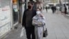A couple walks in Enghelab Square in Tehran on March 26. Amid a deadly outbreak of coronavirus in Iran, alleged miracle cures and misinformation have spread online.