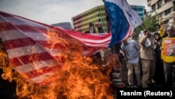 Іранці палять прапор США, протестуючи проти рішення Дональда Трампа про вихід з ядерної угоди. 11 травня 2018 року