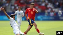 Хусанов испан футболшысы Фермин Лопездің аяғына допты тартып алып жатқан сәт. 2024 жылғы жазғы олимпиада, Өзбекстан мен Испания құрамаларының кездесуі.