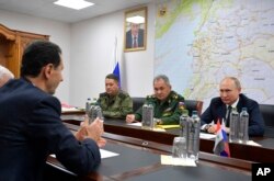 Președintele rus Vladimir Putin (dreapta), secondat de comandanții armatei, îl ascultă pe președintele sirian Bashar Assad la Damasc, în urmă cu aproape cinci ani.